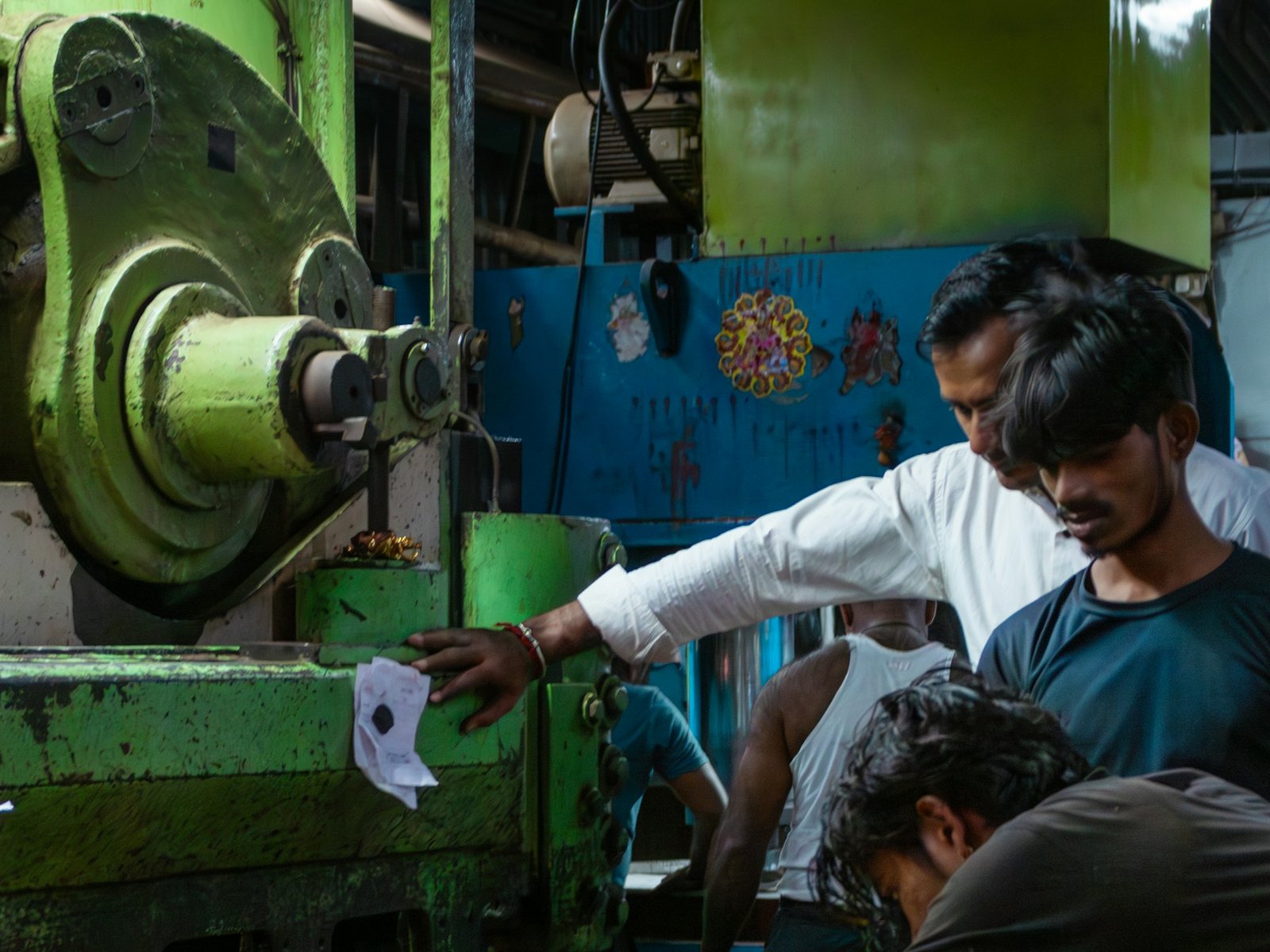 Indian metal fabrication workers operating workshop machinery